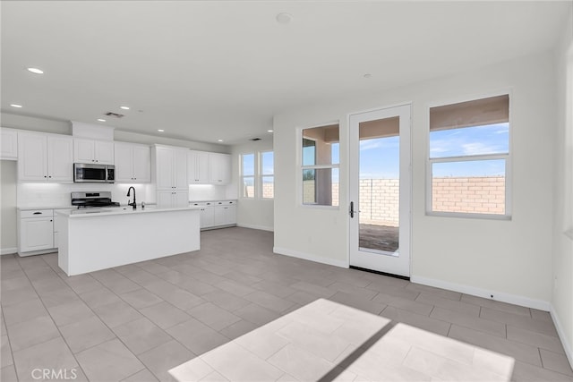 7444 Desert Sky Dr, Yucca Valley, CA 92284 - kitchen with appliances with stainless steel finishes, white cabinets, light countertops, a kitchen island with sink, and recessed lighting