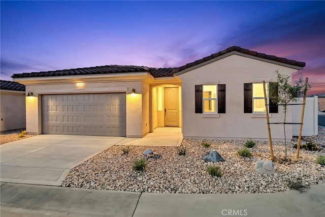 7444 Desert Sky Dr, Yucca Valley, CA 92284 - view of front of home with concrete driveway, a garage, stucco siding, and a tile roof