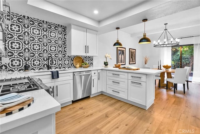1059 Hillview Cir, Simi Valley, CA 93065 - kitchen with dishwasher, a peninsula, a raised ceiling, a chandelier, and light wood finished floors