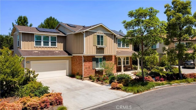 103 Sabiosa, Irvine, CA 92618 - view of front of house with board and batten siding, driveway, a garage, solar panels, and brick siding