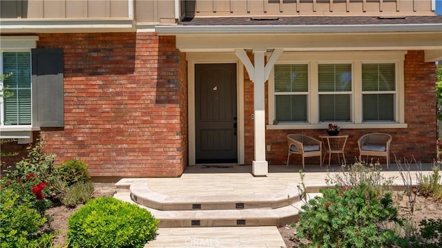 103 Sabiosa, Irvine, CA 92618 - view of exterior entry with a porch, brick siding, board and batten siding, and roof with shingles
