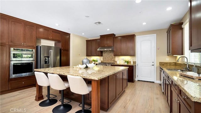 103 Sabiosa, Irvine, CA 92618 - kitchen with stainless steel appliances, a kitchen island, tasteful backsplash, light wood-style flooring, and recessed lighting