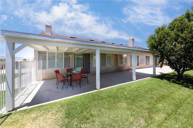 13161 Mugu Ct, Apple Valley, CA 92308 - back of property featuring a patio area, a lawn, a chimney, and stucco siding