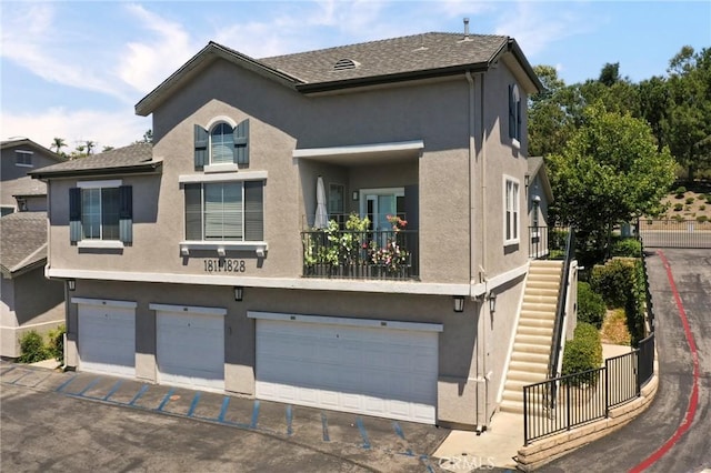 20000 Plum Canyon Rd Unit 1827, Saugus, CA 91350 - view of front of property with stucco siding, an attached garage, stairway, and driveway