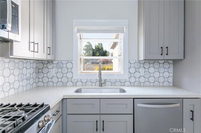 783 E Grand Ave, Pomona, CA 91766 - kitchen featuring stainless steel appliances, light countertops, gray cabinets, and decorative backsplash