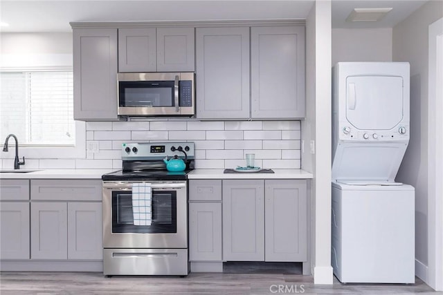783 E Grand Ave, Pomona, CA 91766 - kitchen featuring gray cabinetry, appliances with stainless steel finishes, and stacked washing machine and dryer