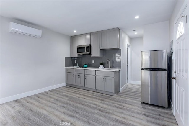 783 E Grand Ave, Pomona, CA 91766 - kitchen with stainless steel appliances, gray cabinets, a wall unit AC, light countertops, and recessed lighting