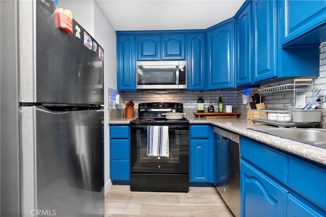 1110 Ohio Ave Unit 107, Long Beach, CA 90804 - kitchen featuring appliances with stainless steel finishes, blue cabinetry, light wood-style floors, and backsplash