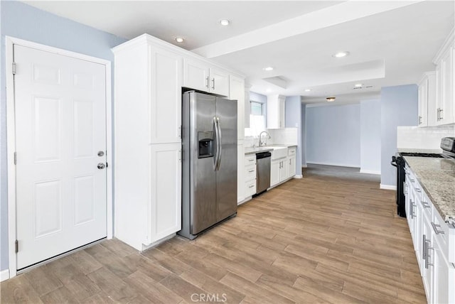 42397 Santiago Dr, Hemet, CA 92544 - kitchen featuring appliances with stainless steel finishes, white cabinets, tasteful backsplash, light stone counters, and light wood-style flooring
