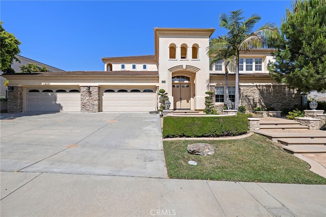 2189 Wind River Ln, Rowland Heights, CA 91748 - mediterranean / spanish house with concrete driveway, an attached garage, stone siding, and stucco siding