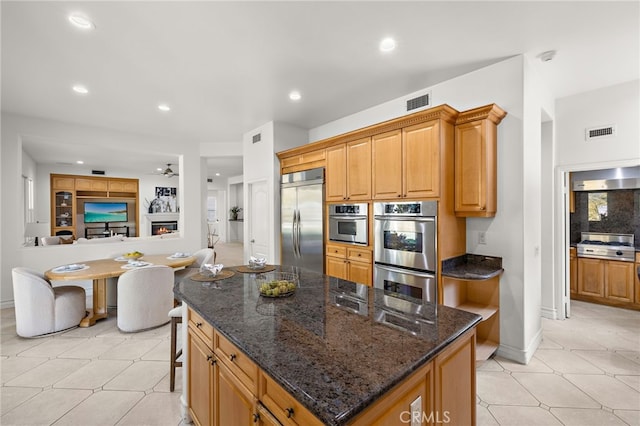 2189 Wind River Ln, Rowland Heights, CA 91748 - kitchen with stainless steel appliances, ceiling fan, a kitchen island, dark stone counters, and recessed lighting