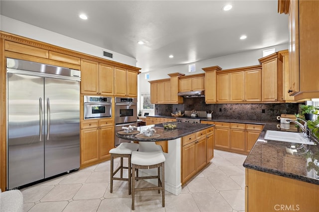 2189 Wind River Ln, Rowland Heights, CA 91748 - kitchen featuring stainless steel appliances, under cabinet range hood, a center island, a breakfast bar, and recessed lighting