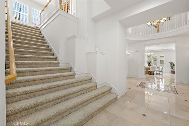 2189 Wind River Ln, Rowland Heights, CA 91748 - stairs featuring a chandelier, a high ceiling, and marble finish floors