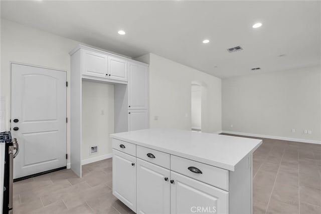 7432 Desert Sky Dr, Yucca Valley, CA 92284 - kitchen featuring recessed lighting, white cabinets, arched walkways, light countertops, and a kitchen island