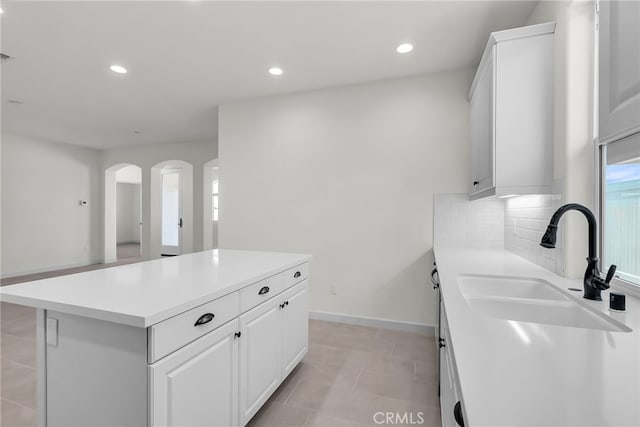 7432 Desert Sky Dr, Yucca Valley, CA 92284 - kitchen with light countertops, arched walkways, a center island, recessed lighting, and decorative backsplash