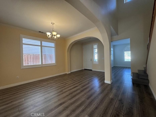 14610 Baylor Ave, Chino, CA 91710 - unfurnished living room with ornamental molding, a chandelier, dark wood-style flooring, and arched walkways