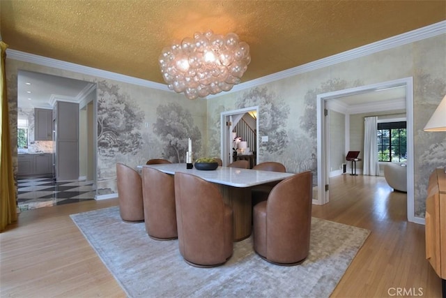 5005 Los Feliz Blvd, Los Angeles, CA 90027 - dining room featuring light wood-type flooring, crown molding, a chandelier, wallpapered walls, and a textured ceiling