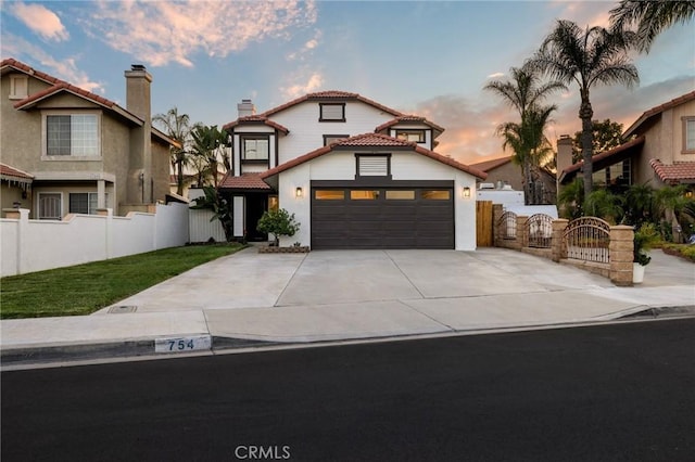 754 Manecita Cir, Perris, CA 92571 - mediterranean / spanish-style home featuring a tile roof, a gate, a garage, concrete driveway, and a chimney