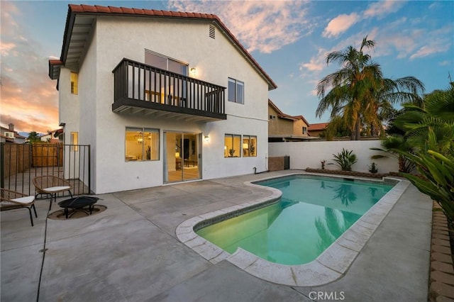 754 Manecita Cir, Perris, CA 92571 - back of property at dusk with a balcony, a fenced backyard, a patio area, and stucco siding
