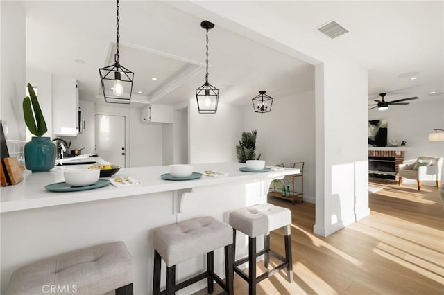 754 Manecita Cir, Perris, CA 92571 - kitchen featuring a peninsula, light wood-type flooring, light countertops, white cabinetry, and recessed lighting