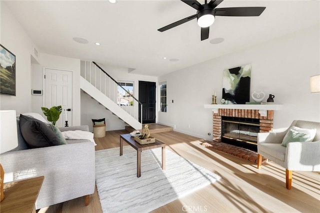754 Manecita Cir, Perris, CA 92571 - living room with stairs, wood finished floors, a brick fireplace, ceiling fan, and recessed lighting
