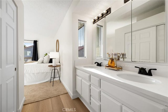 754 Manecita Cir, Perris, CA 92571 - ensuite bathroom with double vanity, wood finished floors, a textured ceiling, and lofted ceiling