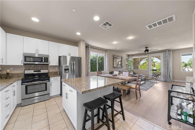 2651 W Lincoln Ave Unit 41, Anaheim, CA 92801 - kitchen with stainless steel appliances, white cabinetry, a center island, recessed lighting, and plenty of natural light