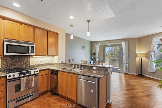 12688 Chapman Ave Unit 3403, Garden Grove, CA 92840 - kitchen featuring stainless steel appliances, dark wood-style floors, a textured ceiling, a peninsula, and tasteful backsplash