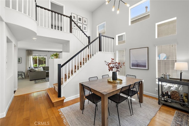 42 Beech Dr, Aliso Viejo, CA 92656 - dining space featuring a towering ceiling, stairway, and hardwood / wood-style floors