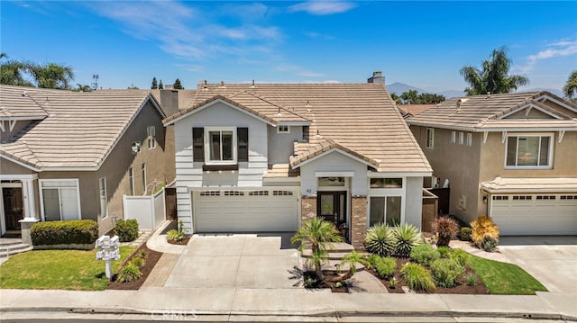 42 Beech Dr, Aliso Viejo, CA 92656 - view of front facade featuring a tile roof, concrete driveway, an attached garage, a chimney, and brick siding