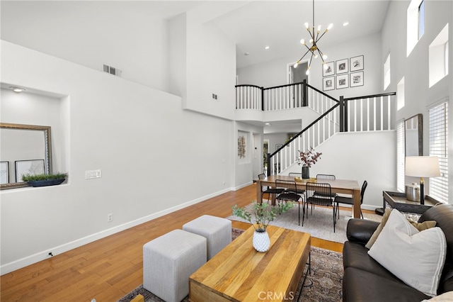 42 Beech Dr, Aliso Viejo, CA 92656 - living area with a towering ceiling, stairway, a chandelier, and wood finished floors