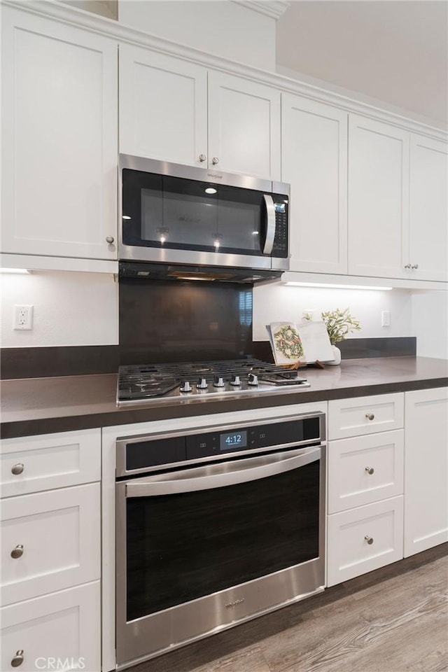 18 Jaripol Cir, Rancho Mission Viejo, CA 92694 - kitchen featuring stainless steel appliances, dark countertops, white cabinetry, and light wood-style floors
