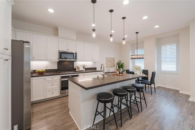 18 Jaripol Cir, Rancho Mission Viejo, CA 92694 - kitchen featuring stainless steel appliances, dark countertops, white cabinetry, recessed lighting, and a breakfast bar area