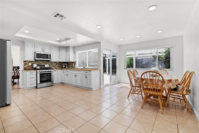 20623 Russ Jay St, Saugus, CA 91350 - kitchen featuring appliances with stainless steel finishes, tasteful backsplash, white cabinetry, recessed lighting, and light tile patterned flooring