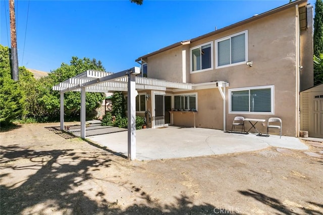 20623 Russ Jay St, Saugus, CA 91350 - rear view of house with stucco siding, a patio, and a pergola