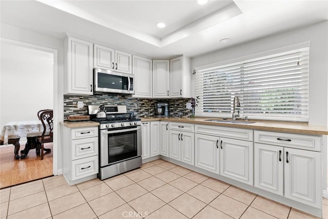 20623 Russ Jay St, Saugus, CA 91350 - kitchen with appliances with stainless steel finishes, light tile patterned floors, decorative backsplash, white cabinets, and recessed lighting
