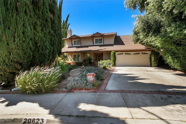 20623 Russ Jay St, Saugus, CA 91350 - view of front of home featuring an attached garage, driveway, a chimney, and stucco siding