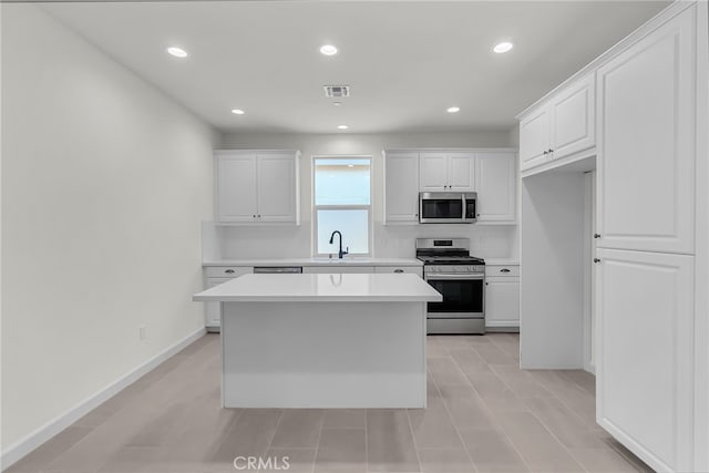 7420 Desert Sky Dr, Yucca Valley, CA 92284 - kitchen featuring stainless steel appliances, white cabinets, light countertops, recessed lighting, and a center island