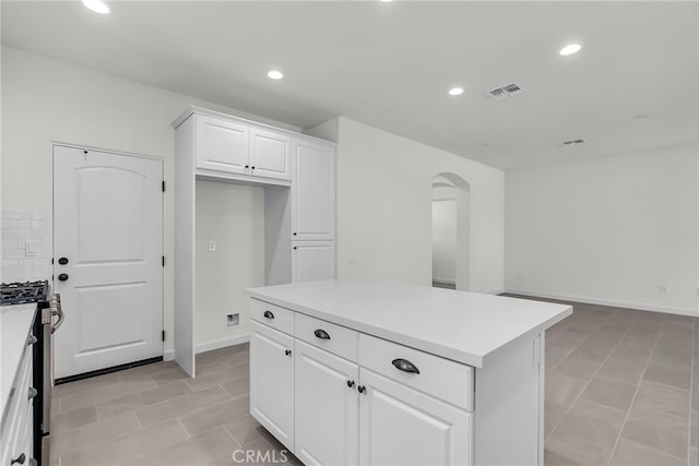 7420 Desert Sky Dr, Yucca Valley, CA 92284 - kitchen with stainless steel gas range, arched walkways, recessed lighting, white cabinetry, and light countertops