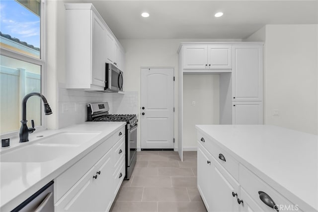7420 Desert Sky Dr, Yucca Valley, CA 92284 - kitchen featuring appliances with stainless steel finishes, white cabinetry, recessed lighting, light countertops, and decorative backsplash