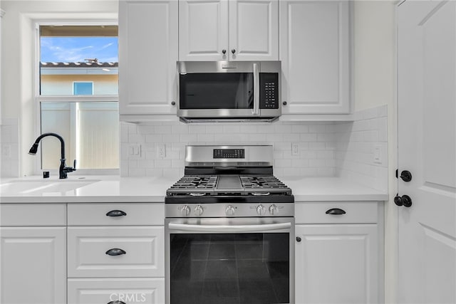 7420 Desert Sky Dr, Yucca Valley, CA 92284 - kitchen with appliances with stainless steel finishes, white cabinetry, light countertops, and tasteful backsplash