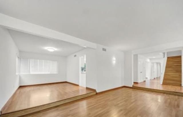 22905 De Kalb Dr, Calabasas, CA 91302 - unfurnished living room featuring wood finished floors and stairway