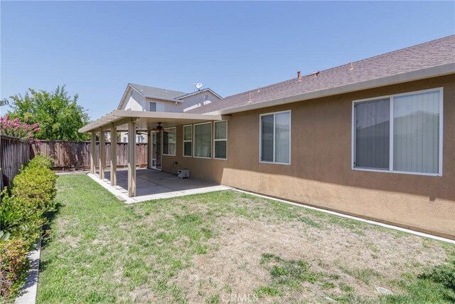 6631 Aggies Ct, Winton, CA 95388 - back of property with a patio area, a fenced backyard, stucco siding, and a ceiling fan