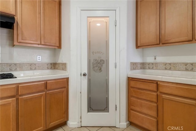 6631 Aggies Ct, Winton, CA 95388 - kitchen featuring ventilation hood, tasteful backsplash, light tile patterned flooring, and tile countertops