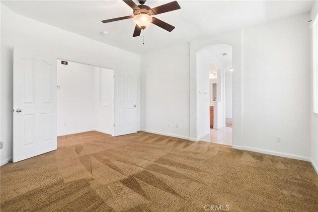 6631 Aggies Ct, Winton, CA 95388 - unfurnished bedroom featuring carpet, arched walkways, a closet, a ceiling fan, and connected bathroom