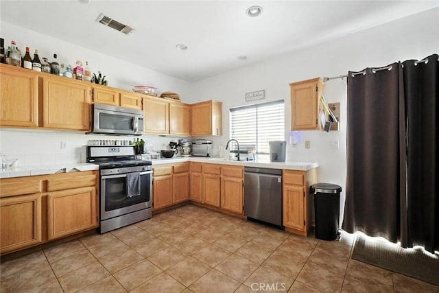 25780 Jumano Dr, Moreno Valley, CA 92551 - kitchen featuring appliances with stainless steel finishes, light tile patterned flooring, and tile counters