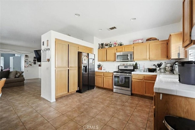 25780 Jumano Dr, Moreno Valley, CA 92551 - kitchen featuring stainless steel appliances, tile countertops, light tile patterned floors, and open floor plan