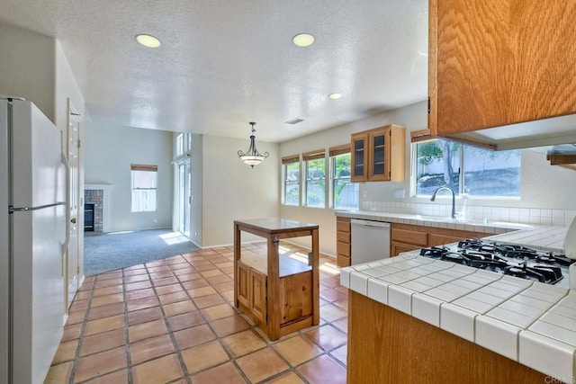 2053 Sequoia St, San Marcos, CA 92078 - kitchen with white appliances, tile counters, light carpet, brown cabinets, and glass insert cabinets