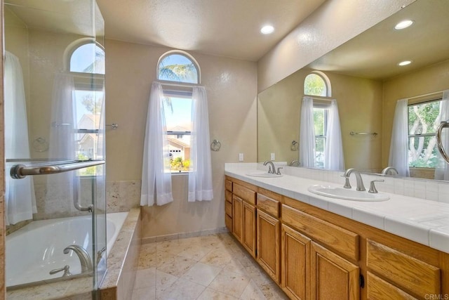 2053 Sequoia St, San Marcos, CA 92078 - bathroom with a relaxing tiled tub, double vanity, plenty of natural light, and recessed lighting