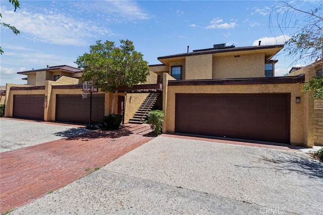 42821 15th St W Unit 4, Lancaster, CA 93534 - view of front of house with stucco siding, stairs, and decorative driveway